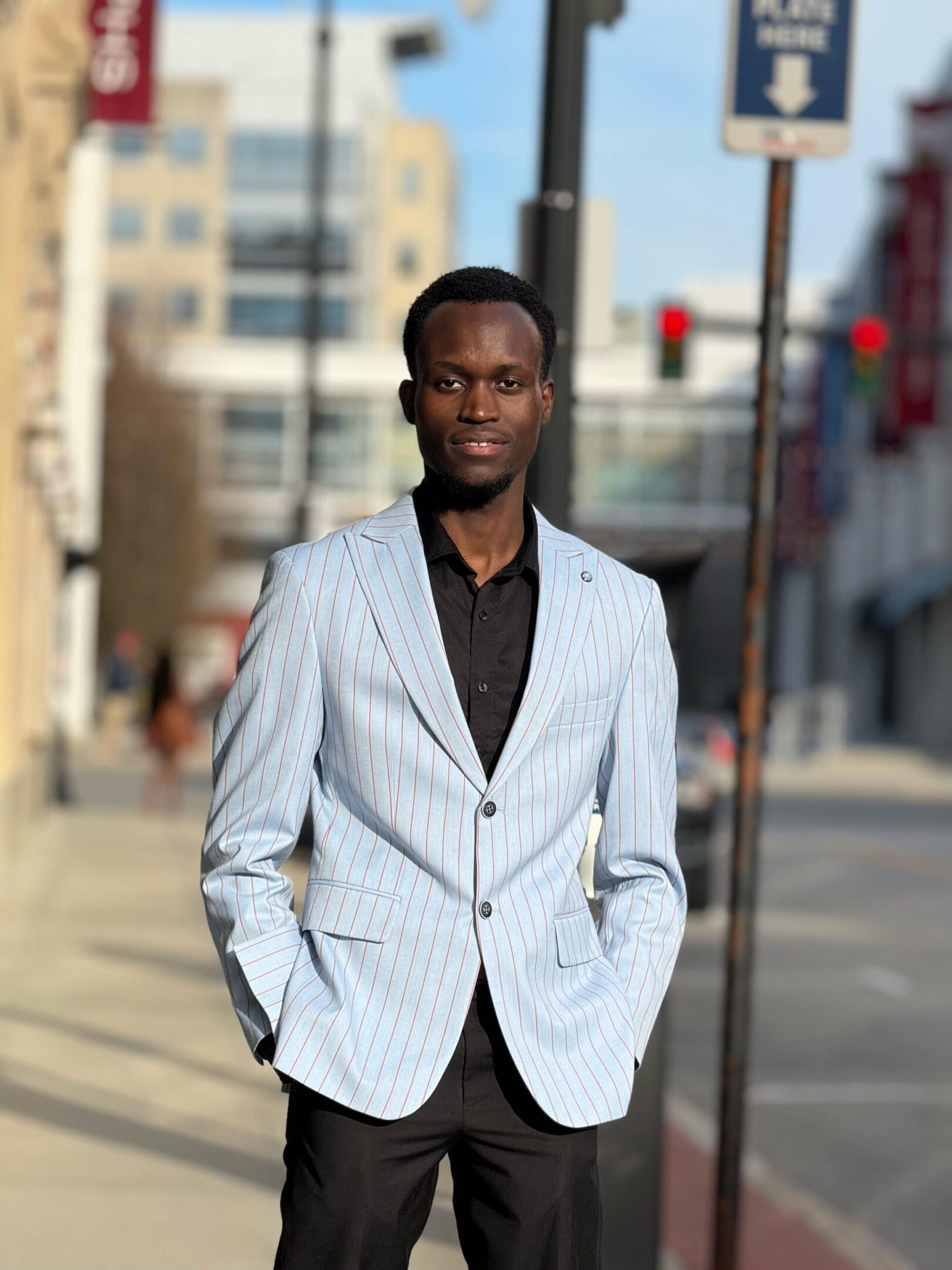 Man wearing light blue pinstripe blazer outdoors